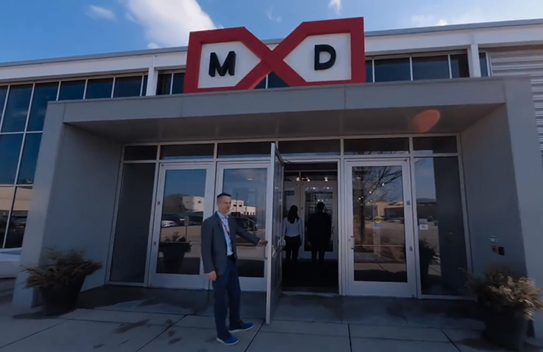 A man holding door at the ey digital operations hub at MXD