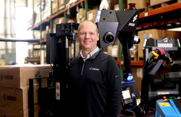 Joe Pajer stands in front of SeeGrid mobile lift trucks.