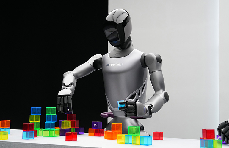 image of a GR-2 humanoid robot picking up various colored cubes from a table.